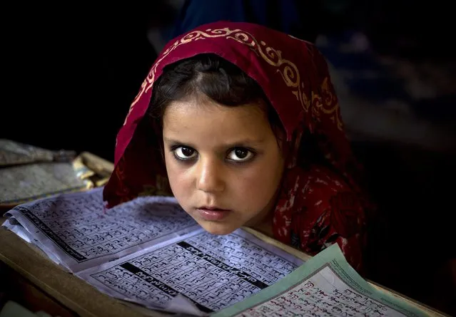An internally displaced Pakistani girl from a tribal area attends her daily lesson at a madrassa, a school for the study of Islam, on the outskirts of Islamabad, Pakistan, Monday, April 6, 2015. (Photo by B. K. Bangash/AP Photo)