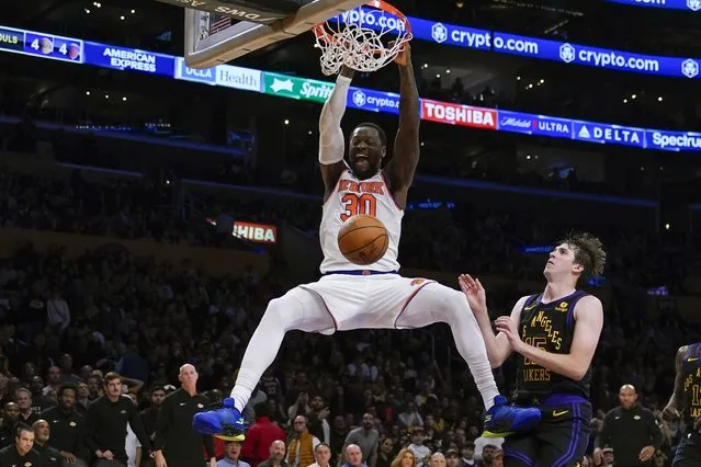 New York Knicks forward Julius Randle (30) dunks the ball against Los Angeles Lakers guard Austin Reaves (15) during the second half of an NBA basketball game, Monday, December 18, 2023, in Los Angeles. (Photo by Ryan Sun/AP Photo)