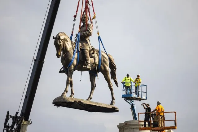 Workers remove the statue of Confederate General Robert E. Lee in Richmond, Virginia, USA, 08 September 2021. Erected more than 130 years ​ago, it is the largest confederate statue in the US. (Photo by Jim Lo Scalzo/EPA/EFE)