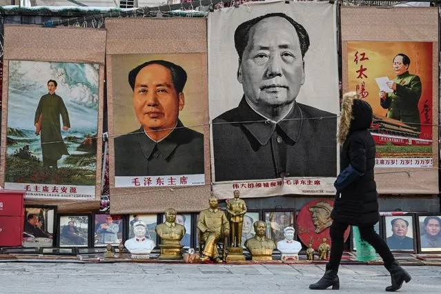 A woman walks past images depicting the late Chinese Communist leader Mao Zedong at a stall in an antique market in Beijing on December 26, 2023, the 130th birth anniversary of communist China's founding father. (Photo by Jade Gao/AFP Photo)