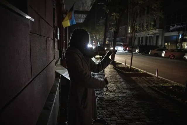 A woman plays the violin on a dark street on November 02, 2022 in Kyiv, Ukraine. Electricity and heating outages across Ukraine caused by missile and drone strikes to energy infrastructure have added urgency preparations for winter. (Photo by Ed Ram/Getty Images)