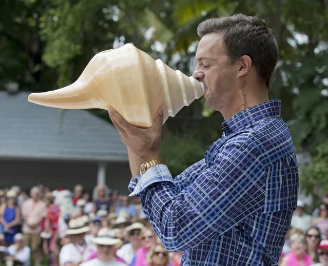 Corey Fritz blows a huge shell during the Annual Conch Shell Blowing Contest in this handout photo provided by the Florida Keys News Bureau, in Key West, Florida,  March 5, 2016. Fritz won the men's division among entrants who were judged on the quality, duration, loudness and novelty of the sounds they produced. (Photo by Rob O'Neal/Reuters/Florida Keys News Bureau)