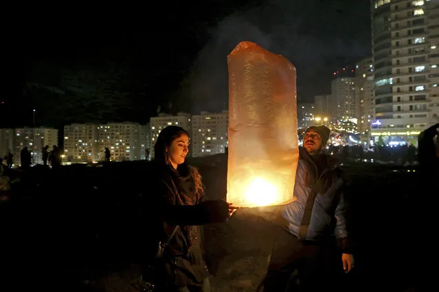 Two Iranians release a lit lantern during a celebration, known as “Chaharshanbe Souri”, or Wednesday Feast, marking the eve of the last Wednesday of the solar Persian year, Tuesday, March 19, 2019, in Tehran, Iran. (Photo by Ebrahim Noroozi/AP Photo)
