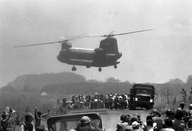 A South Vietnamese air force Chinook helicopter lifts refugees from embattled Xuan Loc area east of Saigon, April 13, 1975, as government and Communist forces continue their fight for control of the provincial capital. (Photo by AP Photo)