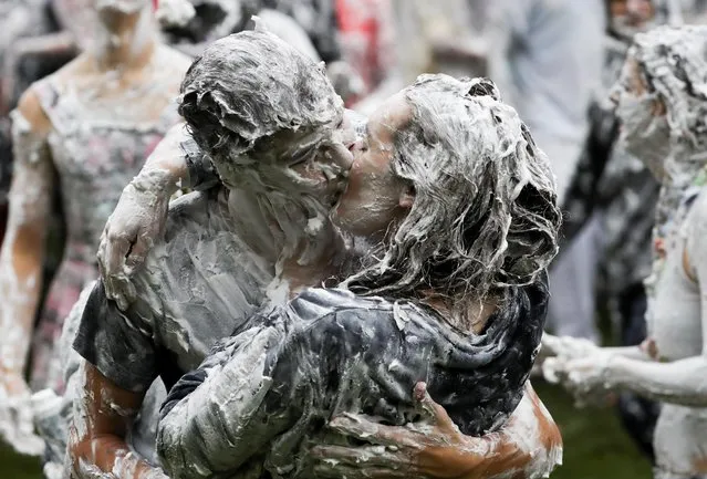 Students from St Andrews University kiss each other, as they are covered in foam during the traditional “Raisin Weekend” in the Lower College Lawn, at St Andrews in Scotland, Britain on October 18, 2021. (Photo by Russell Cheyne/Reuters)