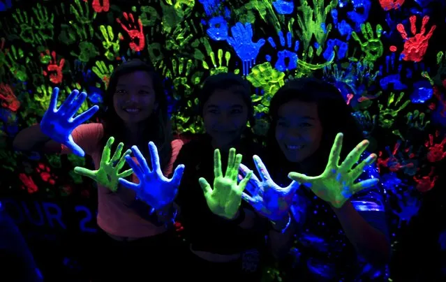 Participants display their hands with neon paints during the Earth Hour in Pasay city, metro Manila, Philippines on March 19, 2016. (Photo by Romeo Ranoco/Reuters)