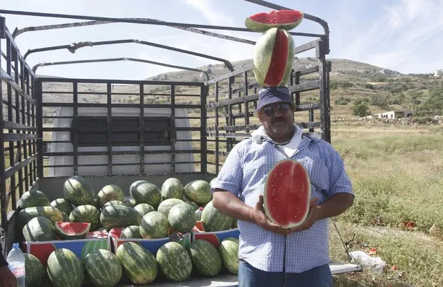 A Palestinian fruit vendor sells watermelons along a roadside at the Israeli army Hawara checkpoint near the West Bank city of Nablus May 4, 2015. (Photo by Abed Omar Qusini/Reuters)