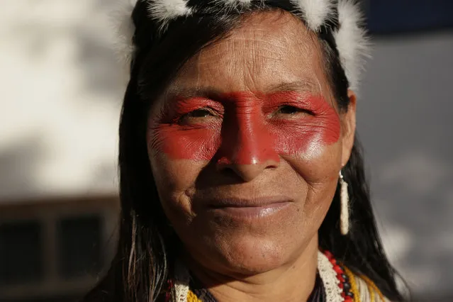 A Waorani woman smiles as she marches with others to a courthouse to attend the ruling on a lawsuit filed by the Waoranis against the Ministry of Non-Renewable Natural Resources for opening up oil concessions on their ancestral land, in Puyo, Ecuador, Friday, April 26, 2019. The judge went on to rule in favor of the Waoranis. (Photo by Dolores Ochoa/AP Photo)