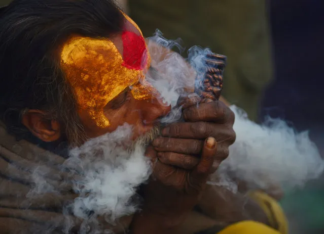 A Nepalese Sadhu (Hindu holy man) smokes a chillum, a traditional clay pipe, as a holy offering to Lord Shiva, the Hindu god of creation and destruction near the Pashupatinath Temple in Kathmandu on Febuary 23, 2017, on the eve of the Hindu festival Maha Shivaratri.
Hindus mark the Maha Shivratri festival by offering prayers and fasting. (Photo by Prakash Mathema/AFP Photo)