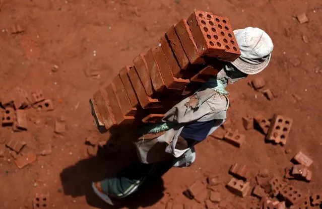 A labourer carries bricks on his back at a traditional brick factory in Arab Mesad district of Helwan, northeast of Cairo, May 14, 2015. (Photo by Amr Abdallah Dalsh/Reuters)