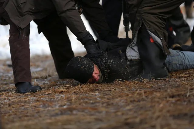 Police detain a man in an attempt to clear the Oceti Sakowin camp in Cannon Ball, North Dakota, U.S., February 23, 2017. (Photo by Stephen Yang/Reuters)