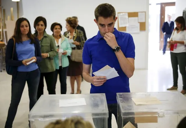 A voter waits to cast his ballot at a polling station during regional and municipal elections in Pozuelo de Alarcon, outside Madrid, Spain, May 24, 2015. Spaniards are expected to sweep aside 40 years of predictable politics when they vote in regional elections on Sunday and usher in an unstable era of coalition and compromise, likely to curtail the authority of Spain's Prime Minister Mariano Rajoy. (Photo by Paul Hanna/Reuters)