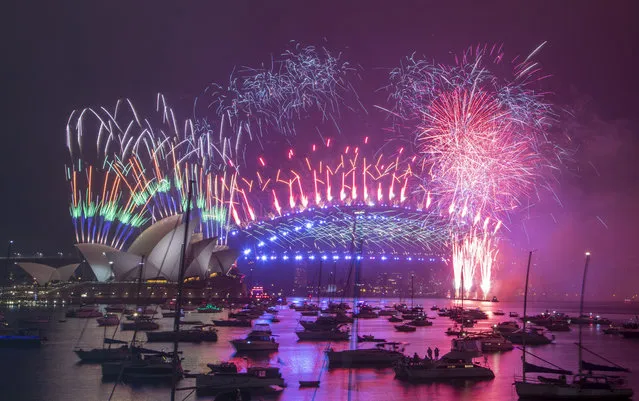 Fireworks explode over the Sydney Opera House and Harbour Bridge as New Year celebrations begin in Sydney, Australia, Friday, January 1, 2021. One million people would usually crowd the Sydney Harbor to watch the annual fireworks that center on the Sydney Harbour Bridge. But this year authorities advised revelers to watch the fireworks on television as the two most populous states, New South Wales and Victoria battle to curb new COVID-19 outbreaks. (Photo by Mark Baker/AP Photo)