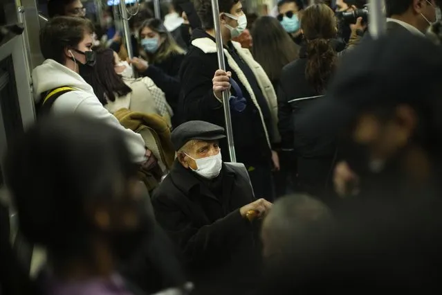 People, all wearing masks to prevent the spread of the COVID-19, take a ride in a metro in Istanbul, Turkey, Thursday, December 2, 2021. The coronavirus's omicron variant kept a jittery world off-kilter Wednesday, as reports of infections linked to the mutant strain cropped up in more parts of the globe, and one official said that the wait for more information on its dangers felt like “an eternity”. (Photo by Francisco Seco/AP Photo)