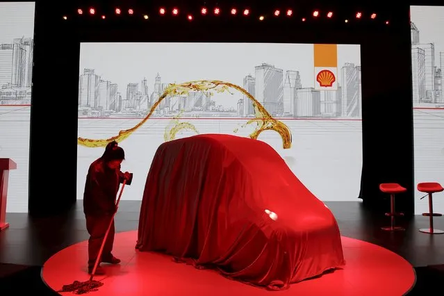 A woman sweeps around a high-efficiency petrol-burning concept car before it is unveiled by Royal Dutch Shell in Beijing, China April 22, 2016. (Photo by Damir Sagolj/Reuters)