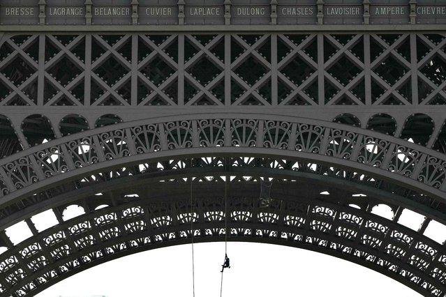 French athlete Anouk Garnier rope climbs up the Eiffel Tower in a bid to break the world record, at the Eiffel Tower in Paris, on April 10, 2024. (Photo by Dimitar Dilkoff/AFP Photo)