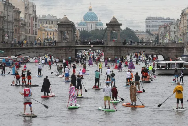 Paddlers take part in the Fontanka-SUP stand up paddle boarding festival in Saint Petersburg, Russia on July 20, 2019. (Photo by Anton Vaganov/Reuters)