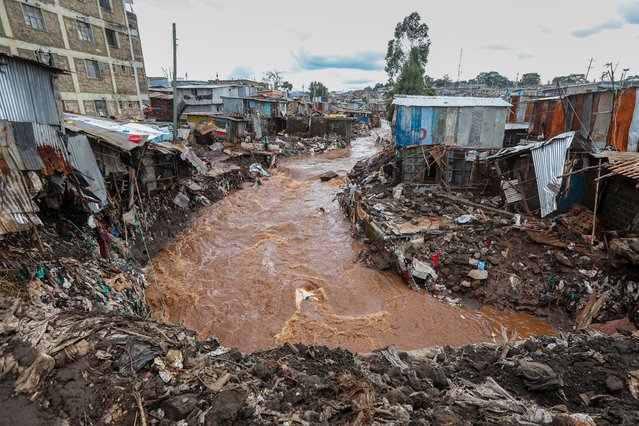 People inspect damaged houses at an area flooded by the Gitathuru river water, a day after it overflowed and broke its banks due to heavy rainfall damaging surrounding neighborhoods, in the Mathare slums, Nairobi, Kenya, 25 April 2024. (Photo by Daniel Irungu/EPA/EFE/Rex Features/Shutterstock)