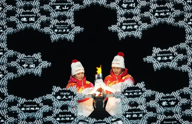 Torch bearers Dinigeer Yilamujiang and Jiawen Zhao of Team China light the Olympic Cauldron during the Opening Ceremony of the Beijing 2022 Winter Olympics at the Beijing National Stadium on February 4, 2022 in Beijing, China. (Photo by Phil Noble/Reuters)