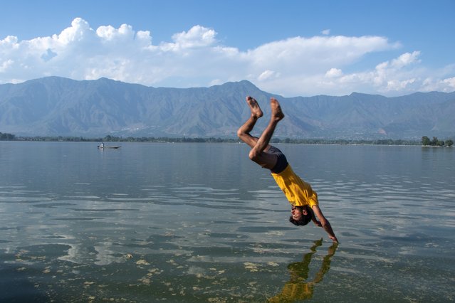 A young boy jumps into Dal Lake to seek relief from the heat on a hot summer day in Srinagar on May 27, 2024. The IMD issued a “Red alert” for a heat wave in northern India on Monday, while a “Yellow alert” has been issued for heat-wave conditions in Jammu and Kashmir, Ladakh, Gilgit-Baltistan, Muzaffarabad, Maharashtra, Himachal Pradesh, Uttarakhand, and eastern Uttar Pradesh. (Photo by Adil Abass/ZUMA Press Wire/Rex Features/Shutterstock)