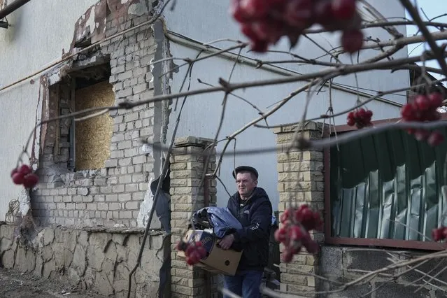 A man takes his things out of the house after damaged by artillery shelling in Novoluhanske, eastern Ukraine, Wednesday, February 23, 2022. U.S. President Joe Biden announced the U.S. was ordering heavy financial sanctions against Russia, declaring that Moscow had flagrantly violated international law in what he called the “beginning of a Russian invasion of Ukraine”. (Photo by Evgeniy Maloletka/AP Photo)