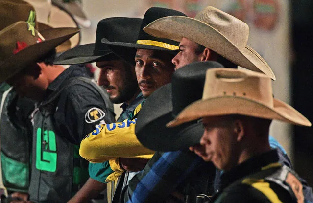 Riders prepare before competing at a rodeo event in Monte Negro, south of the Amazon basin, Rondonia state, Brazil on August 30, 2019. (Photo by Carl De Souza/AFP Photo)