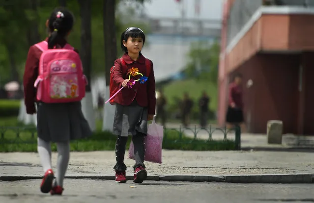 Young girls walk by themselves without adults in Pyongyang, North Korea on May 9, 2016. It's not uncommon to see young kids walking in public alone in North Korea. Some Koreans say they have no worries that the streets or the people on them are unsafe. (Photo by Linda Davidson/The Washington Post)