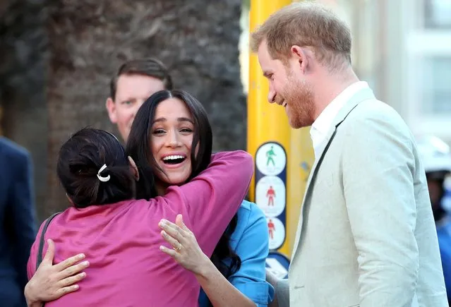 Prince Harry and Meghan, Duchess of Sussex, greet a resident at District Six on the first day of their African tour in Cape Town, South Africa on September 23, 2019. (Photo by Sumaya Hisham/Reuters)