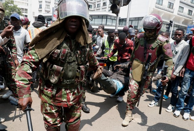 Riot police officers detain a pro-government protester, as they counter an anti-government demonstration following nationwide deadly riots over tax hikes, in Nairobi, Kenya, on July 23, 2024. (Photo by Thomas Mukoya/Reuters)