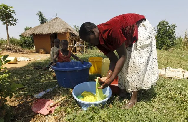 Mary Adhiambo cleans her laundry outside her house in the village of Kogelo, west of Kenya's capital Nairobi, July 15, 2015. Adhiambi, 25, said they benefited from Barack Obama's Presidency as they have well tarmacked roads and electricity has been connected to the village. “We received grants to build houses and shelter from the harsh weather as an indirect benefit from President Obama's leadership”, she said. (Photo by Thomas Mukoya/Reuters)