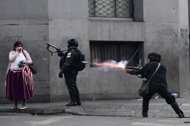 Riot police fire tear gas to disperse supporters of Bolivian ex-President Evo Morales and locals discontented with the political situation during a protest in La Paz on November 13, 2019. Bolivia's exiled ex-president Evo Morales said Wednesday he was ready to return to “pacify” his country amid weeks of unrest that led to his resignation. (Photo by Ronaldo Schemidt/AFP Photo)