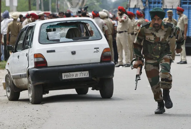 An Indian army soldier takes runs during a fight in the town of Dinanagar, in the northern state of Punjab, India, Monday, July 27, 2015. (Photo by Channi Anand/AP Photo)