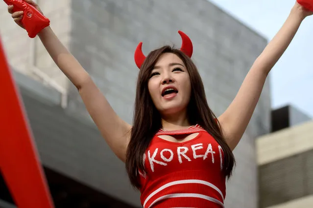 A South Korean football fan reacts during a public screening in Seoul of the South Korea vs Russia football match at the 2014 World Cup in Brazil, early on June 18, 2014. Giant television screens were erected around Seoul ahead of the country's first game at the 2014 Brazilian World Cup. South Korea drew with Russia leaving both countries trailing Belgium who head the Group H table after beating Algeria 2-1 earlier. (Photo by Ed Jones/AFP Photo)