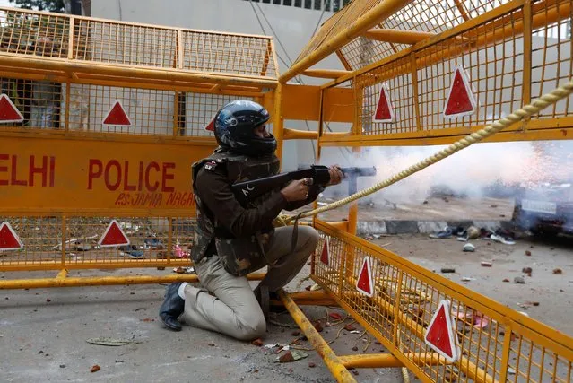A police officer fires a tear gas shell towards protestors during a protest against the Citizenship Amendment Bill, a bill that seeks to give citizenship to religious minorities persecuted in neighbouring Muslim countries, outside the Jamia Millia Islamia University in New Delhi, India, December 13, 2019. (Photo by Adnan Abidi/Reuters)