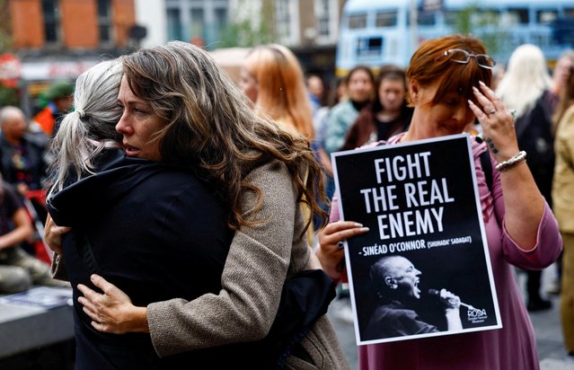 Fans comfort each other as they gather to pay tribute to late Irish singer Sinead O'Connor, following her recent death, in Dublin, Ireland on July 30, 2023. (Photo by Clodagh Kilcoyne/Reuters)