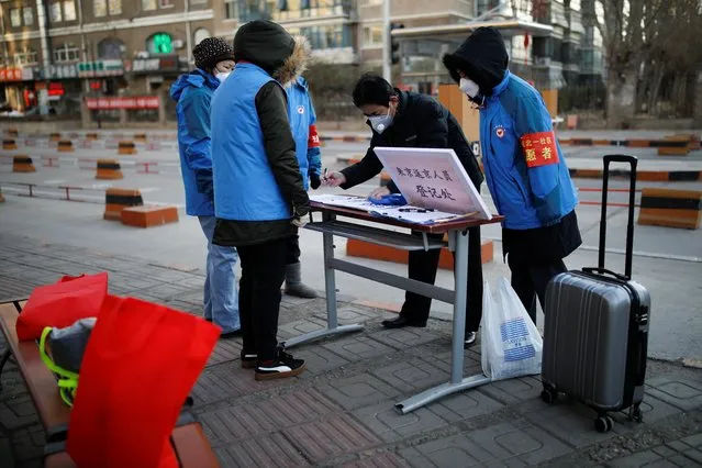 A man wearing a face mask registers at a registration point set up by community members for people returning or leaving Beijing, in Beijing, China, February 1, 2020. (Photo by Carlos Garcia Rawlins/Reuters)