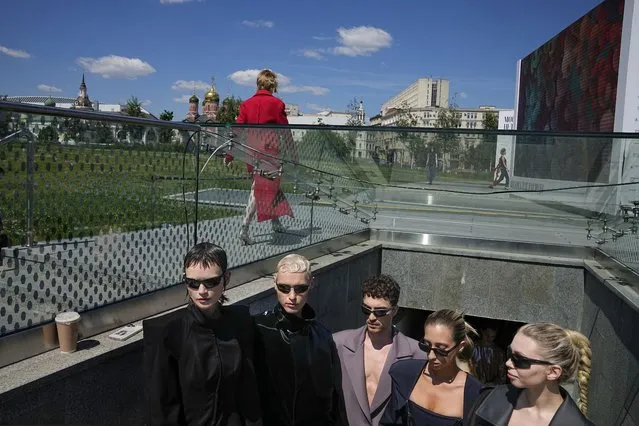 Models gather backstage waiting for their turn to display a collection by graduates of the British Higher School of Art & Design during the Fashion Week at Zaryadye Park near Red Square in Moscow, Russia, Friday, June 24, 2022. (Photo by Alexander Zemlianichenko/AP Photo)