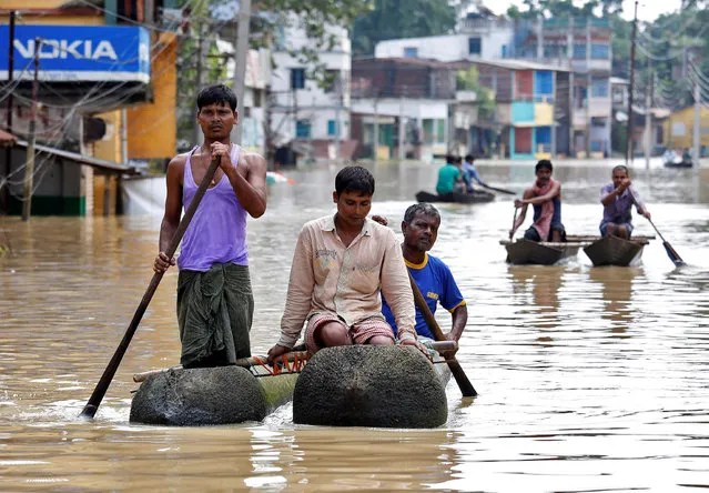 People paddle their boats as they try to move to safer places along a flooded street in West Midnapore district, in West Bengal, July 27, 2017. (Photo by Rupak De Chowdhuri/Reuters)