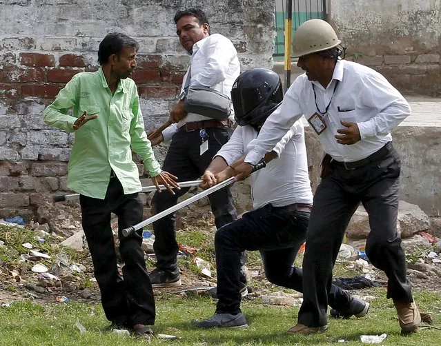 Police wield their batons against a member of the Dalit community after clashes broke out between members of the Patel community and the Dalit community during a protest rally in Ahmedabad, India, August 25, 2015. (Photo by Amit Dave/Reuters)