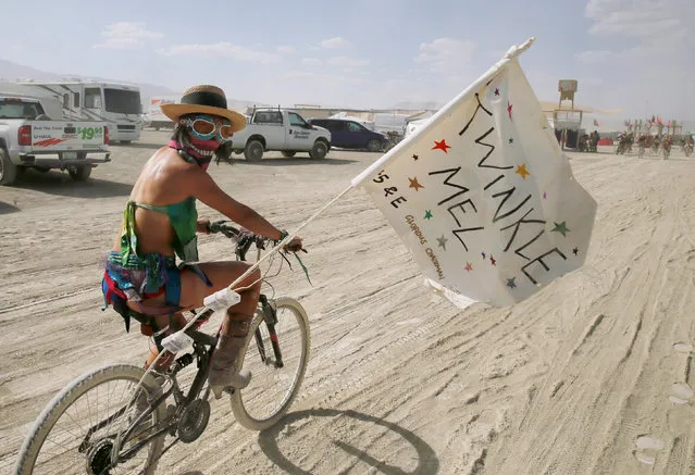 A Burning Man participant who goes by the playa name “Twinkle Mel” bicycles through Black Rock City at Burning Man in the Black Rock Desert of Nevada, U.S. August 29, 2017. (Photo by Jim Urquhart/Reuters)