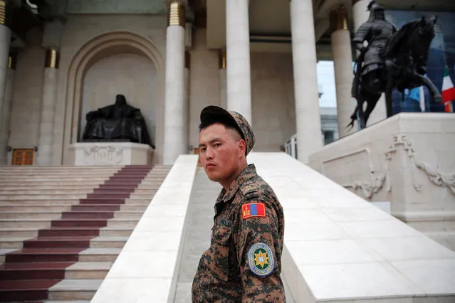 An uniformed guard looks at visitors gathering in front of the statue of Genghis Khan at the parliament building in central Ulaanbaatar, Mongolia, July 13, 2016. (Photo by Damir Sagolj/Reuters)