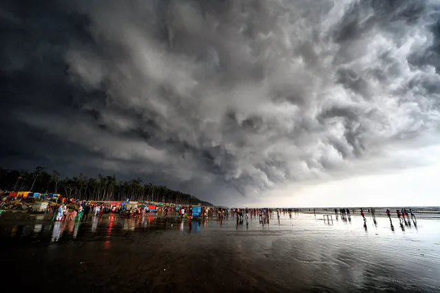 A crowd of people gathered at the seaside of Udaipur, Digha, India before a cloud burst of rain on May 21, 2022. India Meteorological Department (IMD) has predicted that the Monsoon rain will likely arrive a week early this year due to twin cyclones, Asani and Karim. (Photo by Avishek Das/SOPA Images/LightRocket via Getty Images)