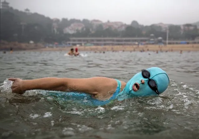 A Chinese woman wears a face-kini as she swims on August 20, 2014 on the Yellow Sea in Qingdao, China. The locally designed mask is worn by many local women to protect them from jellyfish stings, algae and the sun's ultraviolet rays. (Photo by Kevin Frayer/Getty Images)