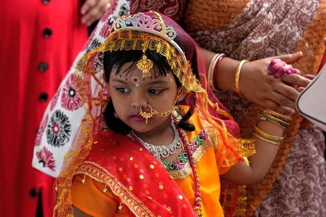 A child dressed as Radha, the consort of Hindu god Krishna, participates in celebrations to mark  Janmashtami festival in Kolkata, India, Friday, August 19, 2022. Janmashtami celebrates the birth of Hindu god Krishna. (Photo by Bikas Das/AP Photo)