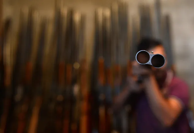 A Kashmiri gunsmith checks a rirfle inside a factory in Srinagar on September 1, 2015. India's government imposed a ban on civilian firearms licenses in the early 1990s, when a rebellion broke out against Indian rule. The two factories that produce these guns have also been limited by the government to production of 300-400 guns a year. (Photo by Tauseef Mustafa/AFP Photo)