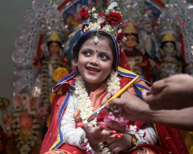 Chayanika Ganguly, 7yrs old gets her final make up before Kumari Puja rituals in Kolkata. An Indian girl Chayanika Ganguly, 7yrs old dressed as Goddess Durga worshipped during the Kumari Puja ritual as a part of the Durga Puja festival at Bholanath Dham on September 28, 2017 in Kolkata. The Kumari (young pre pubescent girl) Puja is a ritual of worshipping a girl aged between six to twelve years, as manifestation of the female energy or Devi in Hindu religious tradition. (Photo by Saikat Paul/Pacific Press/Barcroft Images)