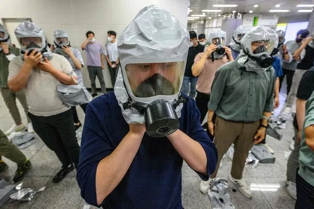 Civilians put on gas masks as they participate in an anti-terror and anti-chemical drill on the sidelines of the joint South Korea-US Ulchi Freedom Shield (UFS) military exercises, at a metro station in Incheon, west of Seoul, on August 24, 2022. (Photo by Anthony Wallace/AFP Photo)
