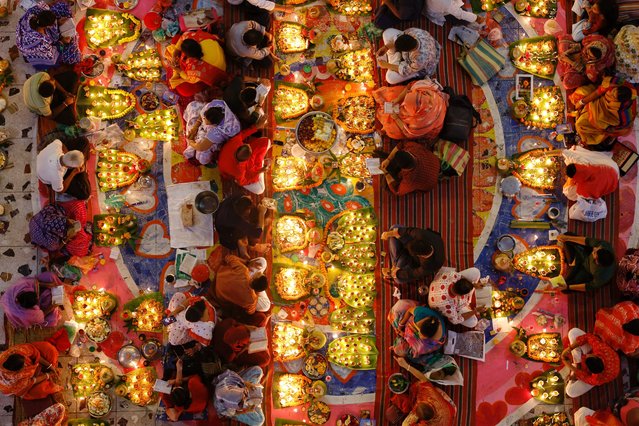 Hindu devotees sit together in front of oil lamps and candles, and pray to Lokenath Brahmachari, a Hindu saint and philosopher, as they observe the Rakher Upobash festival, at a temple in Dhaka, Bangladesh, on November 12, 2024. (Photo by Mohammad Ponir Hossain/Reuters)