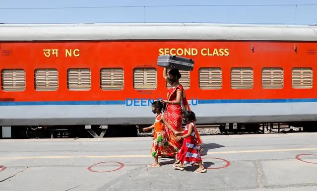 A migrant family walks to board train, after a limited reopening of India's giant rail network following a nearly seven-week lockdown to slow the spreading of the coronavirus disease (COVID-19), in Greater Noida, India, May 16, 2020. (Photo by Adnan Abidi/Reuters)