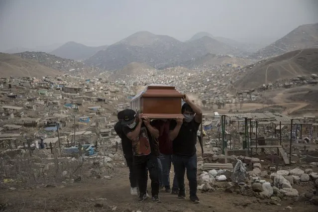 Relatives carry the coffin of a suspected COVID-19 victim at the Nueva Esperanza cemetery on the outskirts of Lima, Peru, Thursday, May 28, 2020. (Photo by Rodrigo Abd/AP Photo)